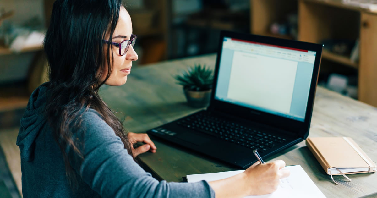 Woman writer working on laptop at desk