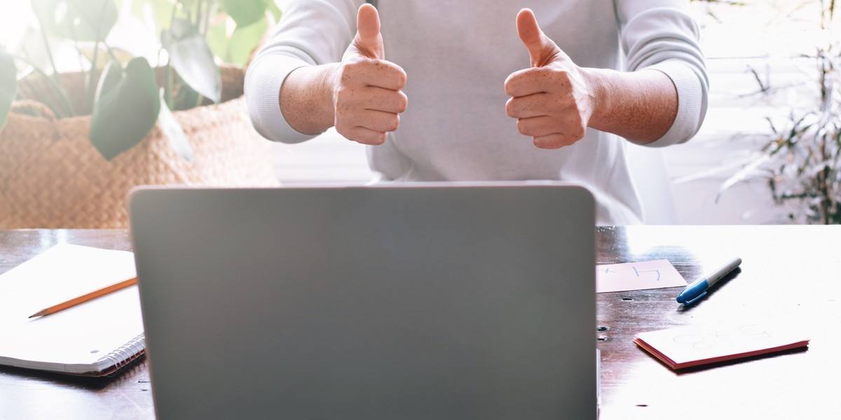 Man giving thumbs up and encouraging someone on computer